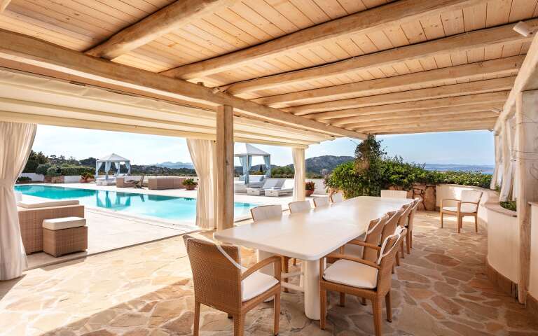 covered al fresco dining area with pool view