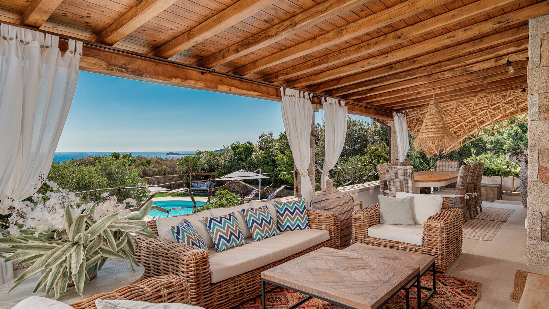 covered sitting area with pool and sea view