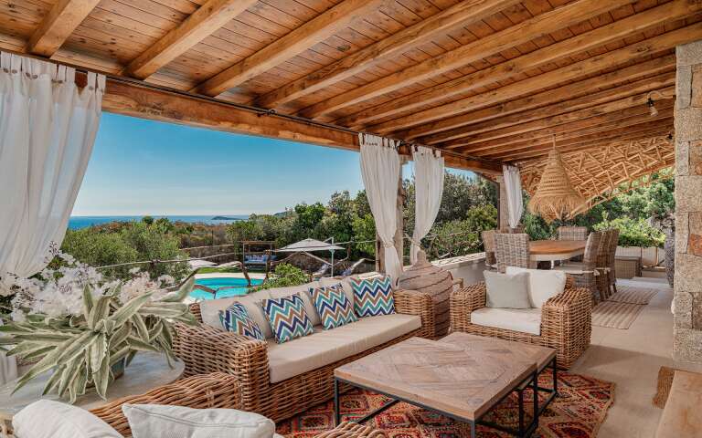 covered sitting area with pool and sea view