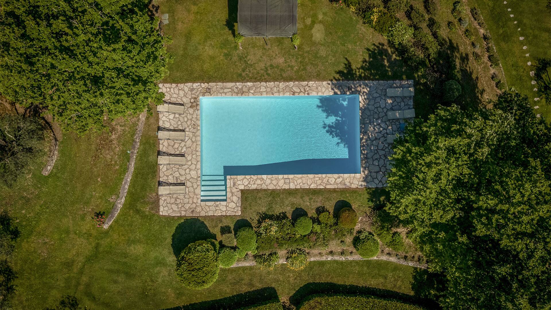 aerial view over private pool and covered lounging area